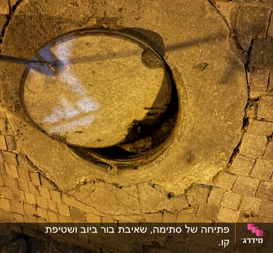 פתיחת מכסה שוחת ביוב עגולה באמצעות מוט ייעודי